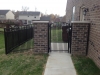 Black aluminum arched gate between columns